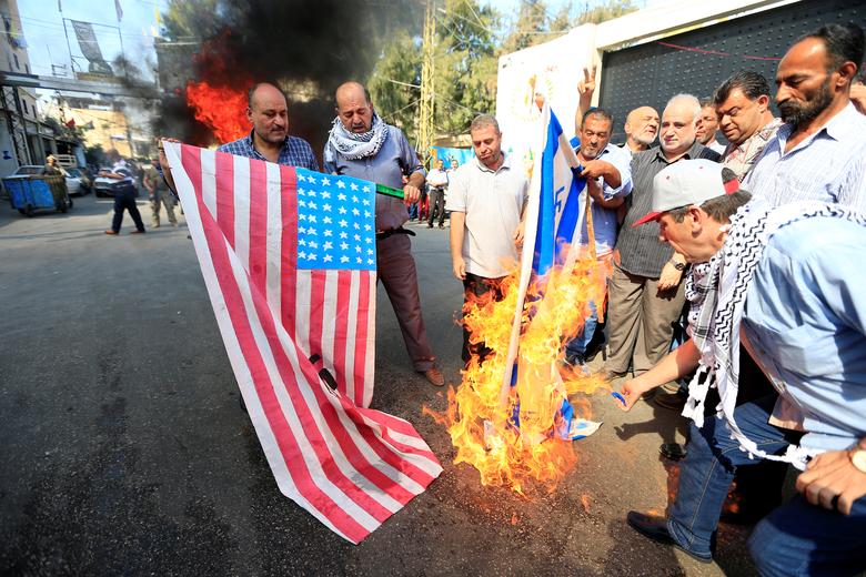 Demonstrators set fire to a makeshift Israeli flag during a protest against Bahrain's conference about U.S. President Donald Trump's vision for Mideast peace plan, in Ain al-Hilweh Palestinian refugee camp, near Sidon, South Lebanon June 25