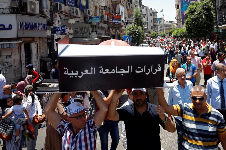 Palestinian demonstrators carry a symbolic coffin reading: 