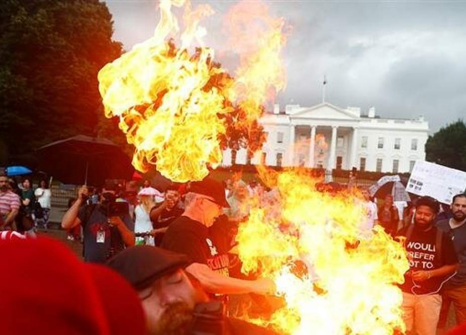 Demonstrators burn a national flag in front of the White House during a Fourth of July Independence Day protest in Washington, DC, July 4, 2019. (Reuters photo)