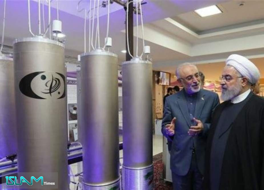 In this file handout photo taken on April 09, 2019 by Iran’s presidential office, Iranian President Hassan Rouhani (2nd L) listens to Ali Akbar Salehi, head of the Atomic Organization of Iran (AEOI), inspect nuclear achievements on the country’s National Nuclear Technology Day