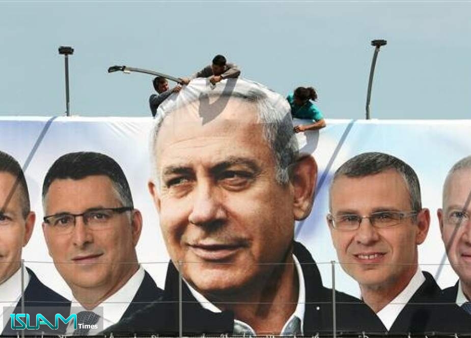 Laborers work on hanging up a Likud election campaign banner depicting Israeli Prime Minister Benjamin Netanyahu (C) with his party candidates in Jerusalem al-Quds on March 28, 2019
