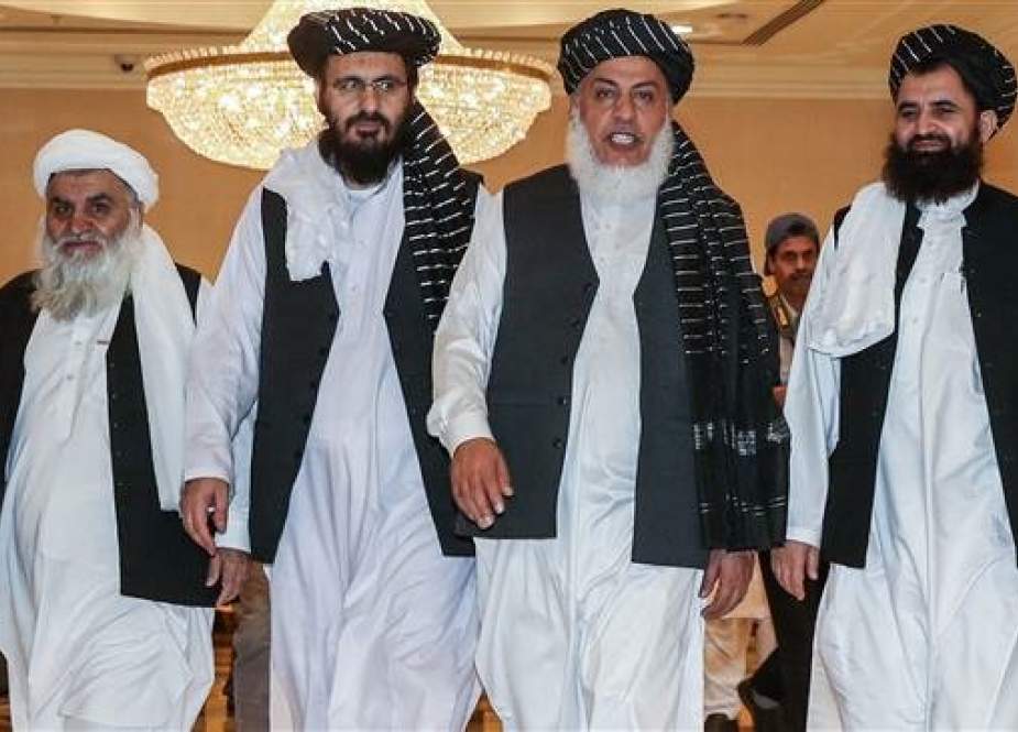 Taliban negotiators walking during the second day of Afghan talks in Doha, Qatar.jpg