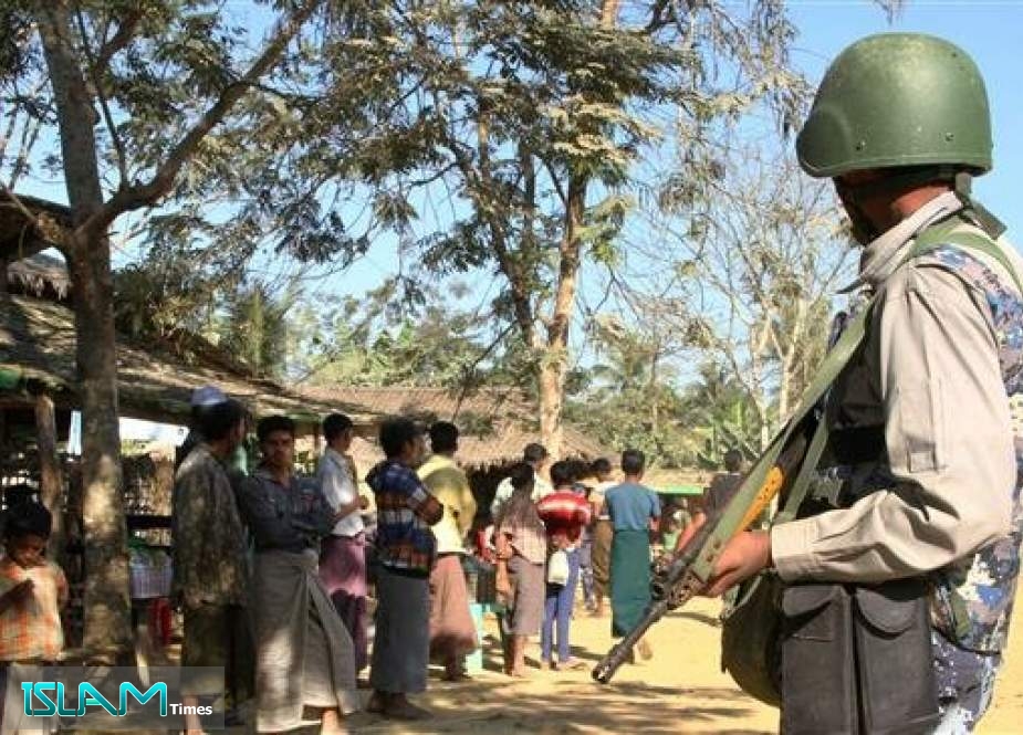 The file photo shows a Myanmar border guard near a group of Rohingya Muslims in a village in Rakhine state, January 25, 2019