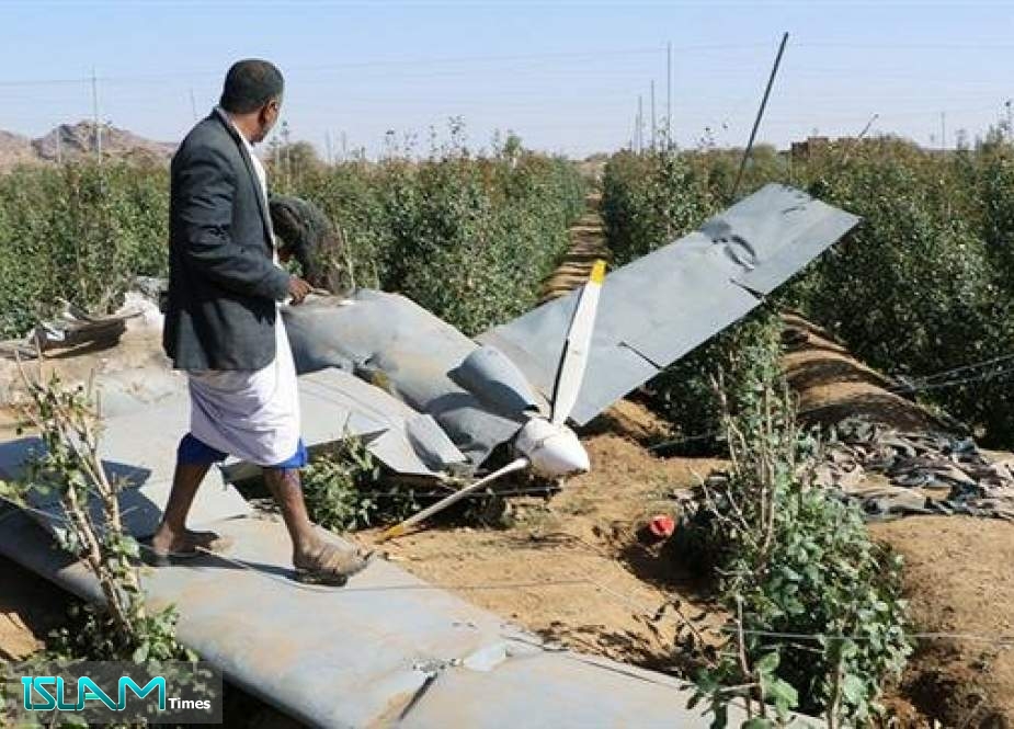 People inspect the wreckage of a drone aircraft reportedly downed by Houthi Ansarullah forces near the northwestern city of Sa’ada
