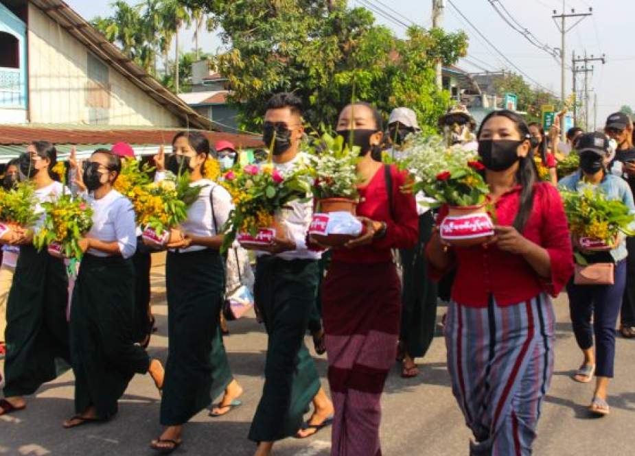 This handout photo, taken and released by Dawei Watch on April 13, 2021, shows protesters carrying pots filled with Thingyan festival flowers and leaves during a demonstration against a military coup, in Dawei, Myanmar.