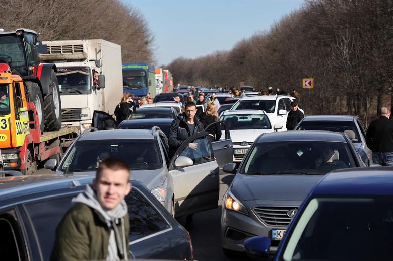 People wait in a traffic jam as they leave the city of Kharkiv, Ukraine, February 24.