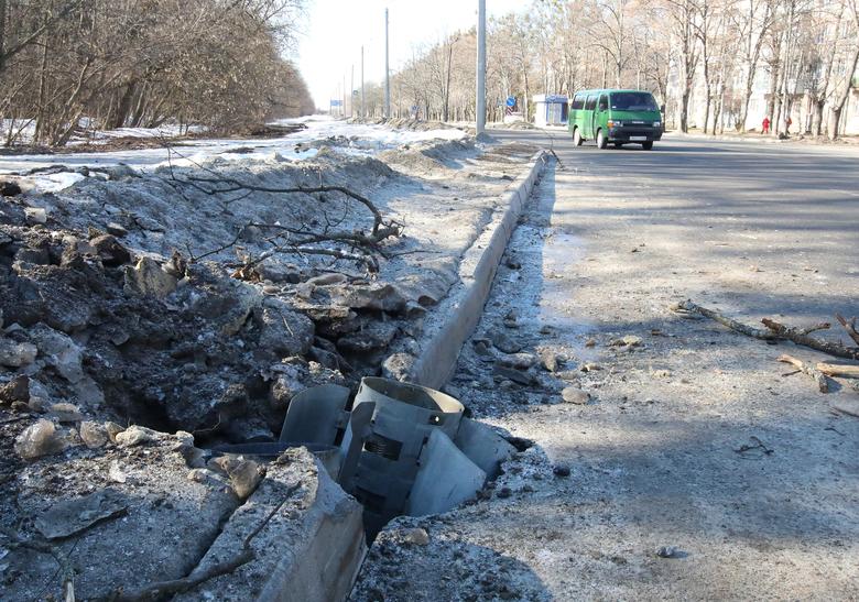 A rocket case lies buried into a road after shelling in Kharkiv, Ukraine, February 24.