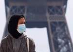 A woman, wearing a hijab and a protective face mask, walks at Trocadero square near the Eiffel Tower in Paris, France, May 2, 2021.