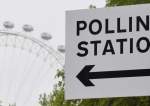 A polling station direction sign is seen with the London Eye wheel behind, ahead of local authority elections, in London, Britain, on May 3, 2022.