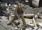 A Ukrainian serviceman examining a destroyed building