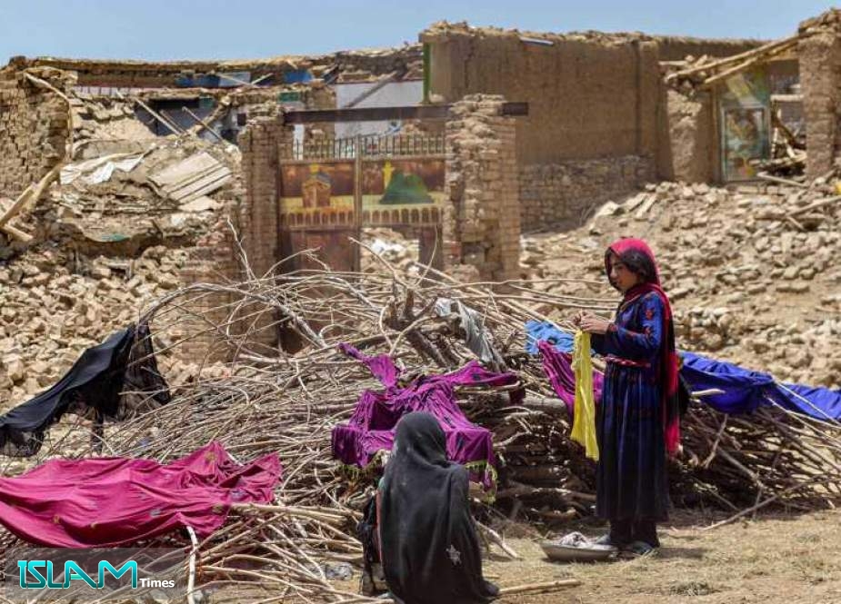 Afghan people keep their clothes to dry on dried-out shrubs near the ruins of houses damaged by an earthquake in Bermal district, Paktika province, on June 23, 2022.