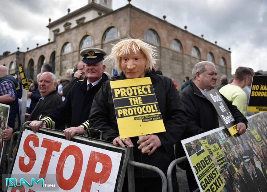A demonstrator in Hillsborough, Northern Ireland wears a Boris Johnson mask at a protest against London