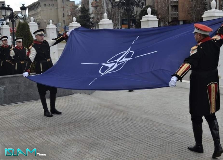 Macedonian soldiers hold the NATO flag during a ceremony in in Skopje