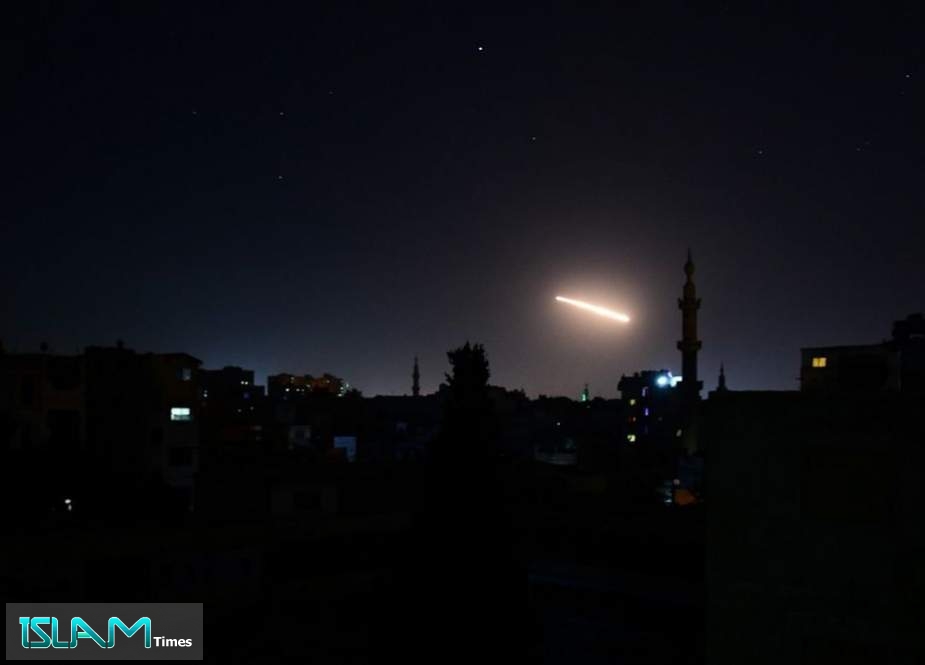 A streak of light is seen in the night sky in the vicinity of the Syrian capital, Damascus, during an Israeli air strike.