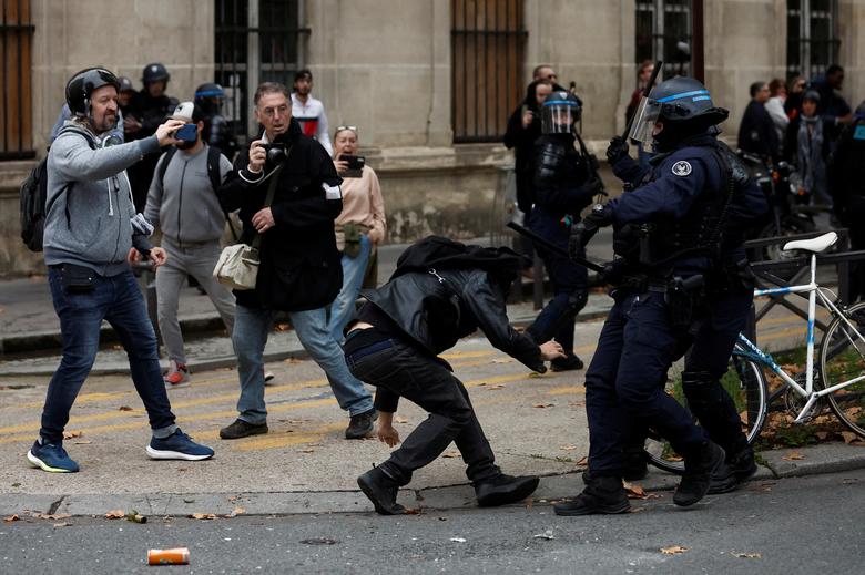 French riot police clash with a protestor at a demonstration in Paris as part of a nationwide day of strike and protests, October 18.