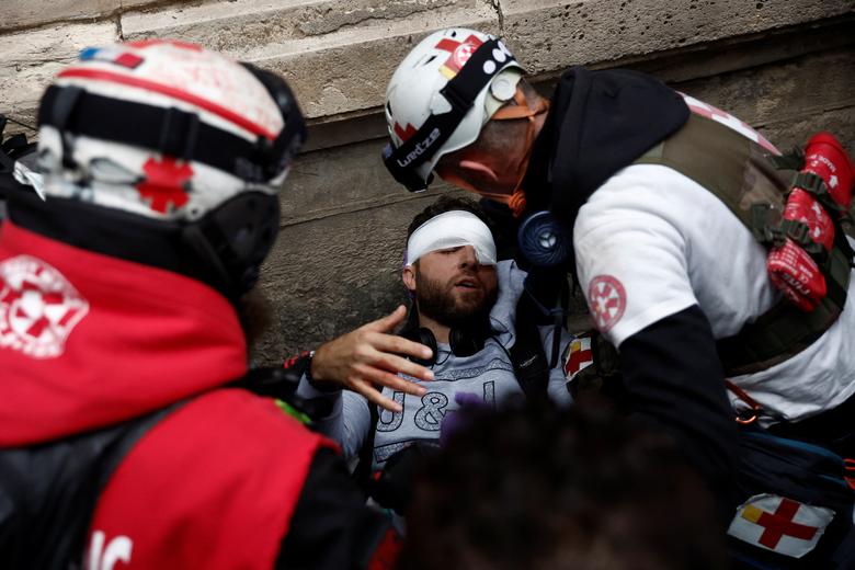 Street medics tend to injured journalist Zakaria Abdelkafi during clashes at a demonstration in Paris, October 18.