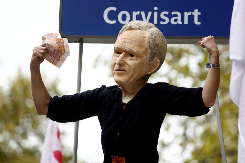 A protestor wearing a mask depicting Bernard Arnault, chairman of LVMH Moet Hennessy Louis Vuitton, attends a demonstration in Paris, October 18.