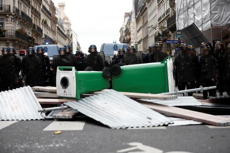 French CRS riot police stand next to a barricade during clashes at a demonstration in Paris, October 18.