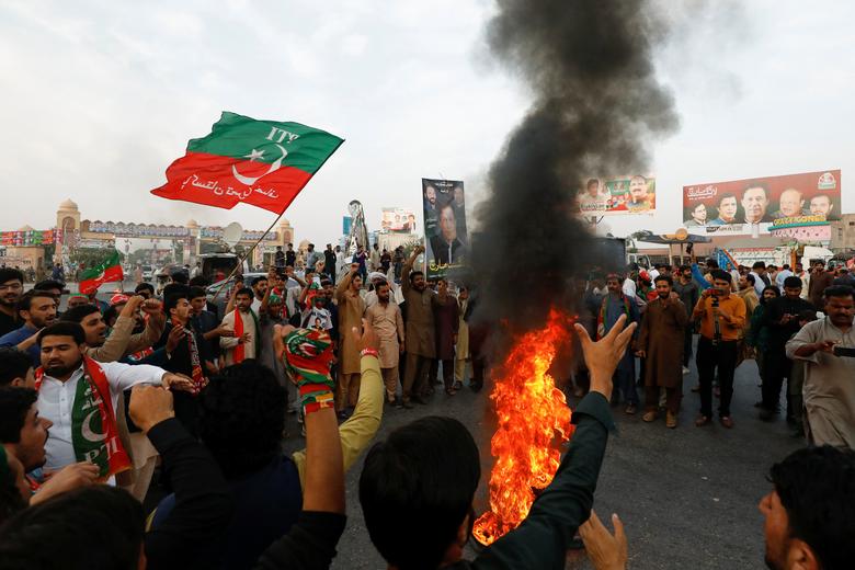 People chant slogans as they burn tires to block main highway during a protest to condemn the shooting incident on a long march held by Pakistan's former Prime Minister Imran Khan, in Wazirabad, Pakistan November 4, 2022.
