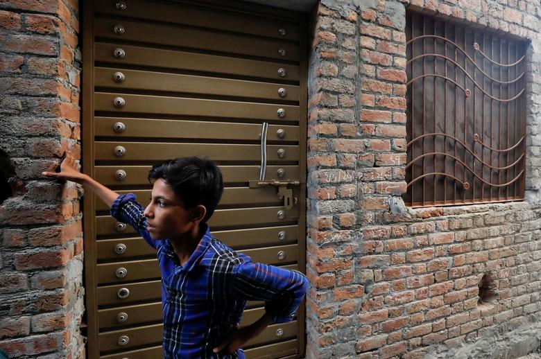 A boy stands outside the residence of Mohammad Naveed, a suspected shooter, according to police, from a long march held by Pakistan former Prime Minister Imran Khan, in Wazirabad, Pakistan November 4, 2022.