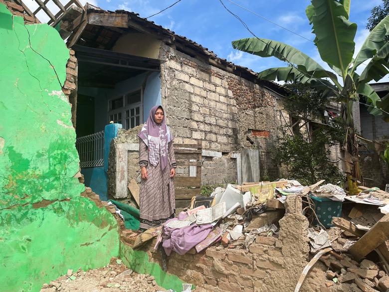 Lalah Latifah, 26, mother of Anisa Nazwah Khalifah, a student who was found dead under the ruins of her Islamic boarding school, stands near the rubbles where her daughter was found, following an earthquake in Cianjur, Indonesia, November 23, 2022.