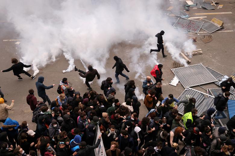 Protesters throw tear gas canisters back amid clashes during a demonstration against French government's pension reform, in Paris, France, March 23.  REUTERS/Nacho Doce