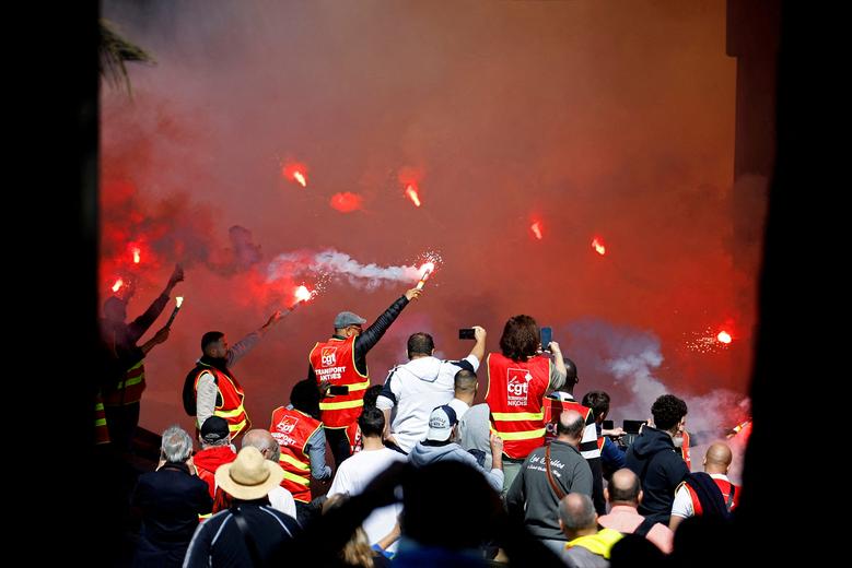 Protesters, wearing CGT labour union vests, hold red flares during a demonstration against French government's pension reform, in Nice, France, March 23. REUTERS/Eric Gaillard
