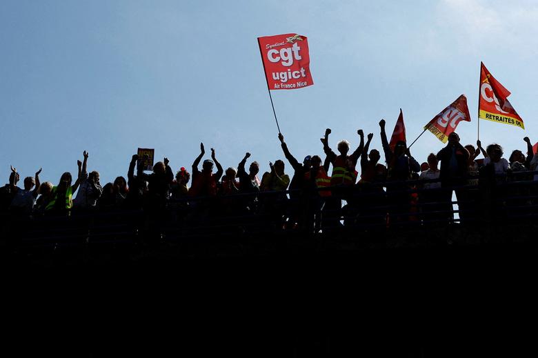 Protesters, holding CGT labour union flags, attend a demonstration against French government's pension reform, in Nice, France, March 23. REUTERS/Eric Gaillard