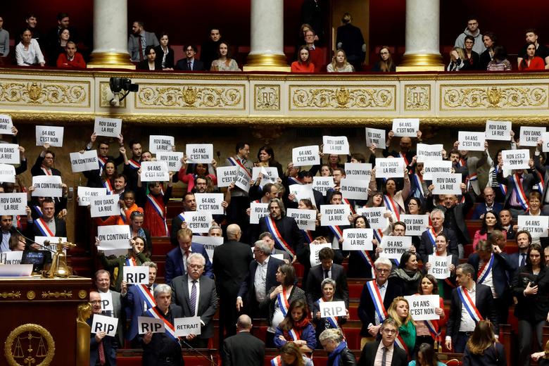 Members of parliament of the left hold placards after the result of the vote on the first motion of no-confidence against the French government, at the National Assembly in Paris, France, March 20. REUTERS/Gonzalo Fuentes