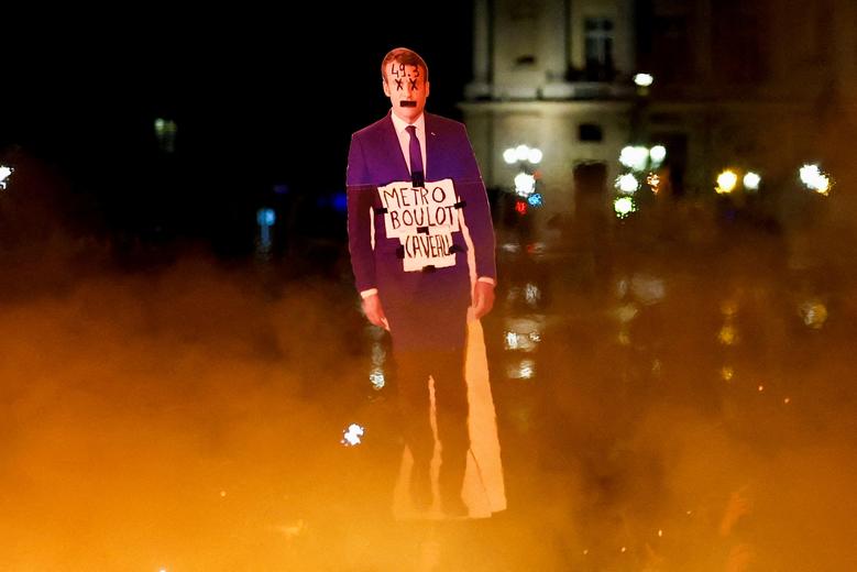 A protester holds a cut-out depicting French President Emmanuel Macron near fire during a demonstration on Place de la Concorde, in Paris, France, March 17. REUTERS/Gonzalo Fuentes