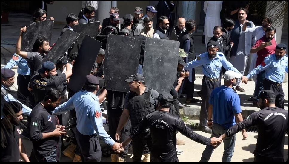Private security personnel with bulletproof shields escort Imran Khan as he arrives to appear in a court, in Islamabad, Pakistan, May 09, 2023
